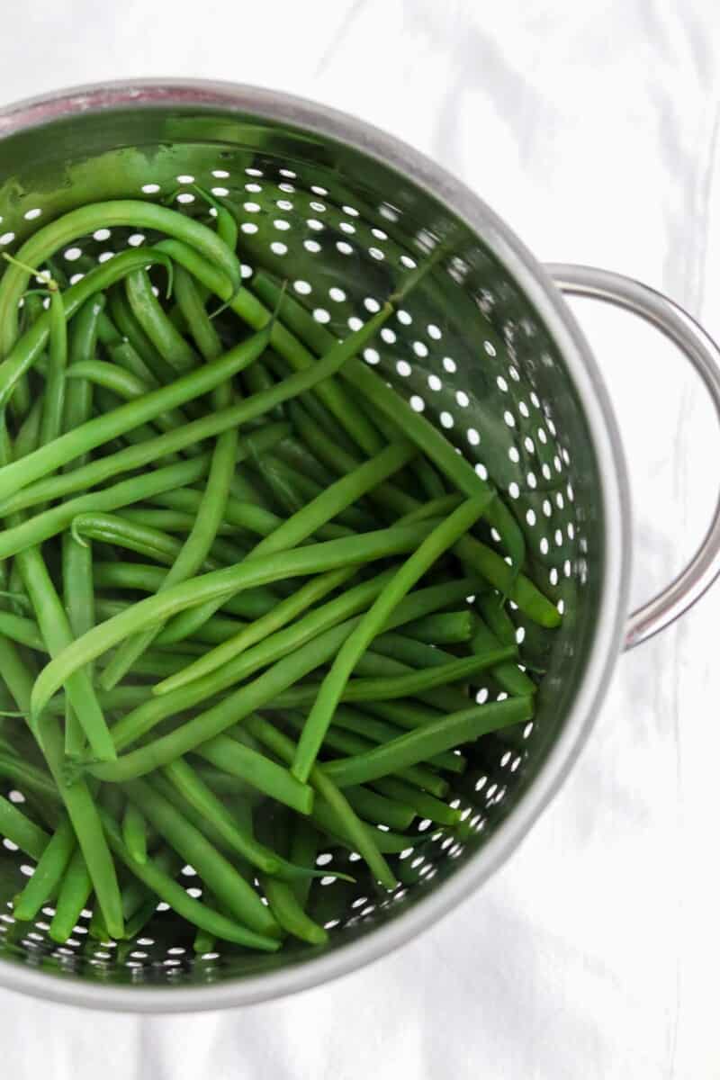 Green beans in a metal colander.