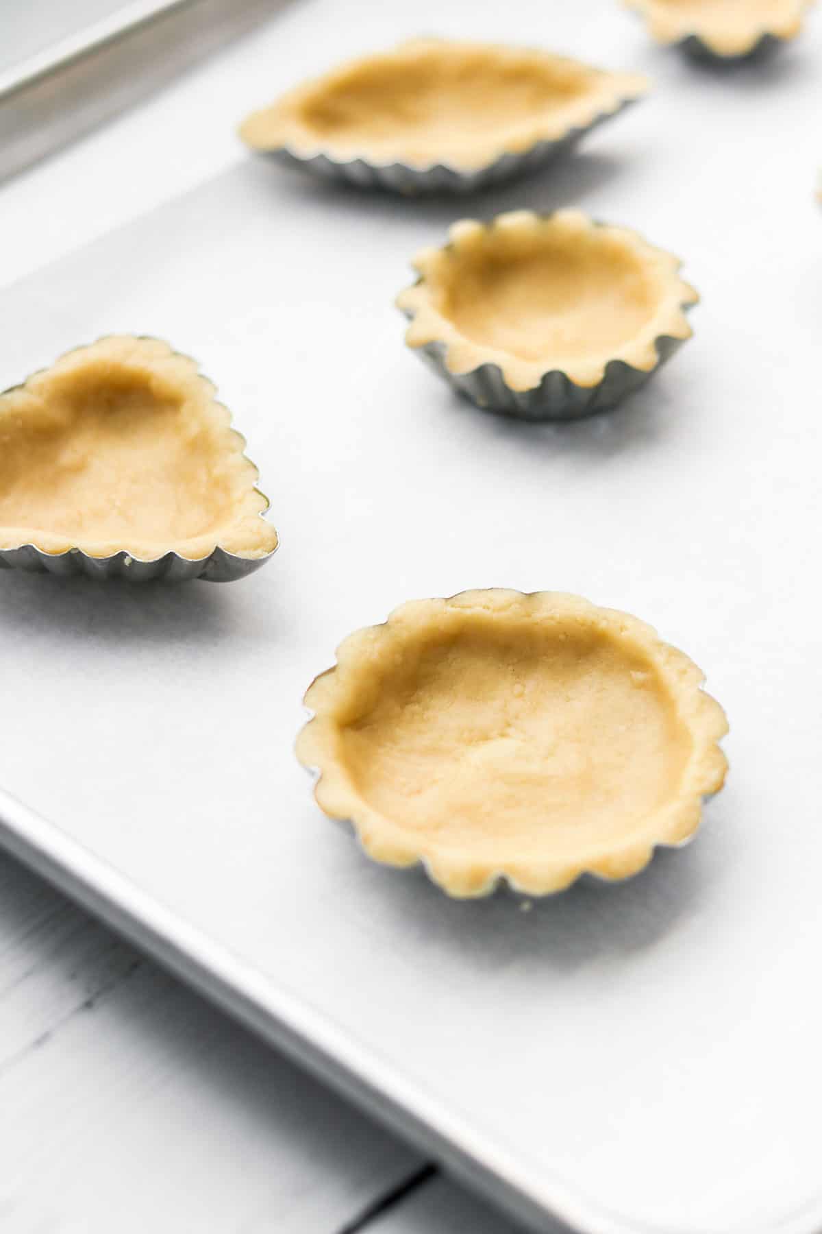 Unbaked Scandinavian Almond Tarts on a cookie sheet lined with parchment paper.