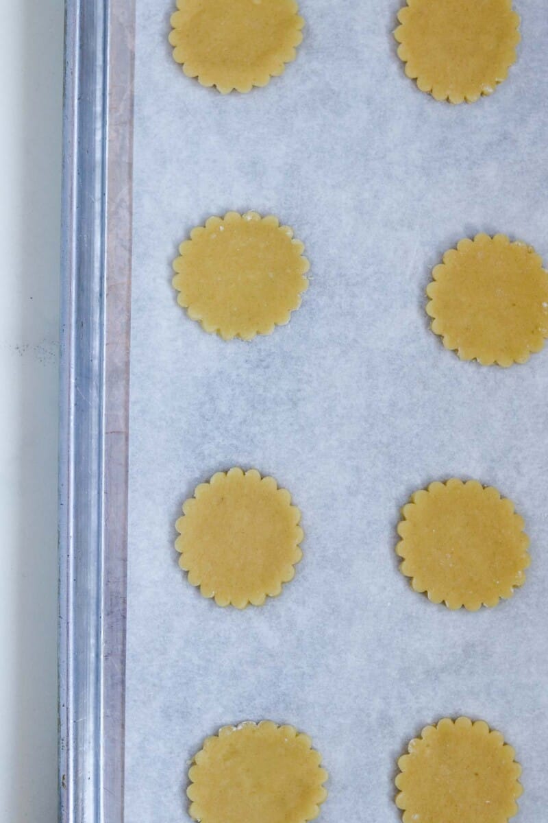 Cut out unbaked cookies on a baking sheet.