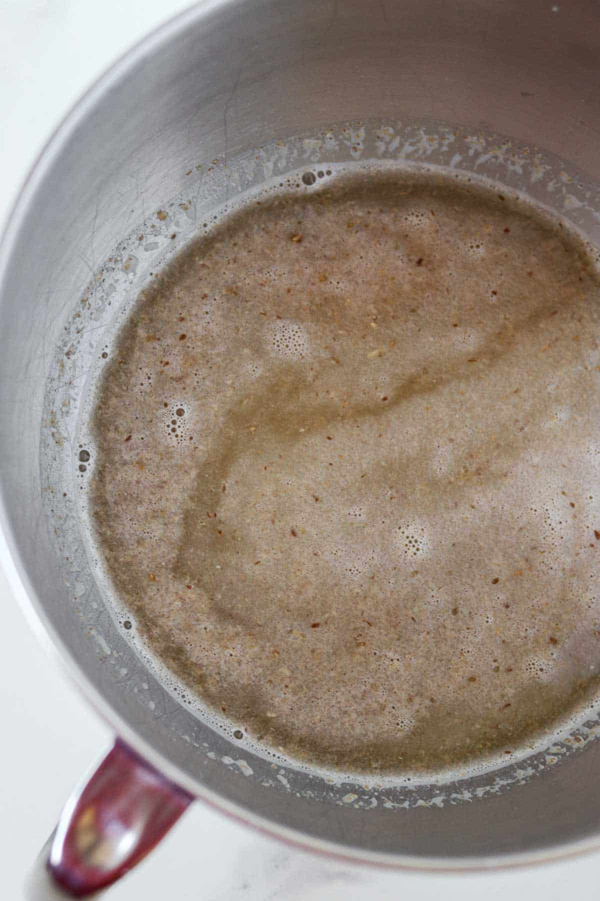 Water and chopped grain cereal in a metal bowl.