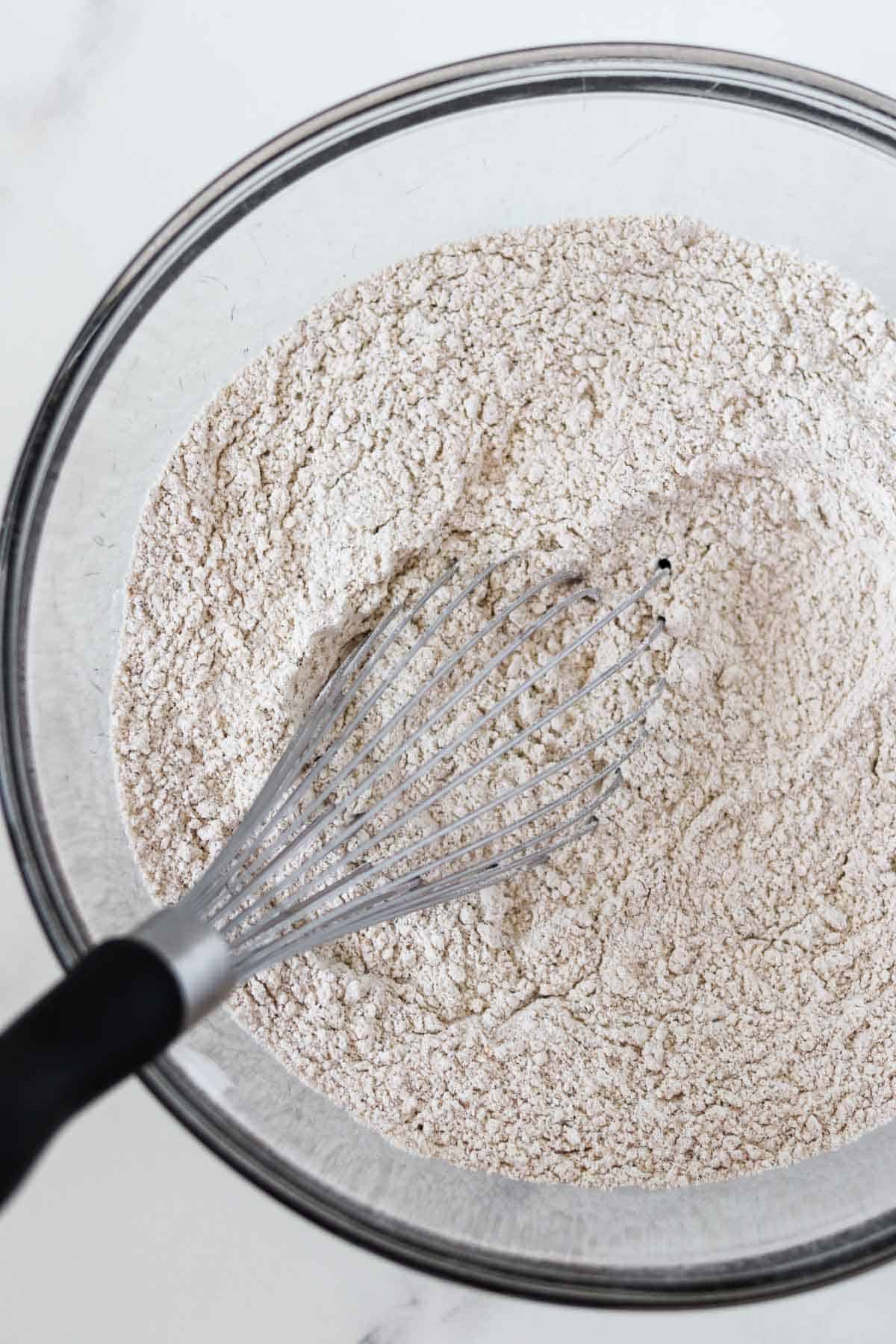 Flour in a bowl with a whisk.
