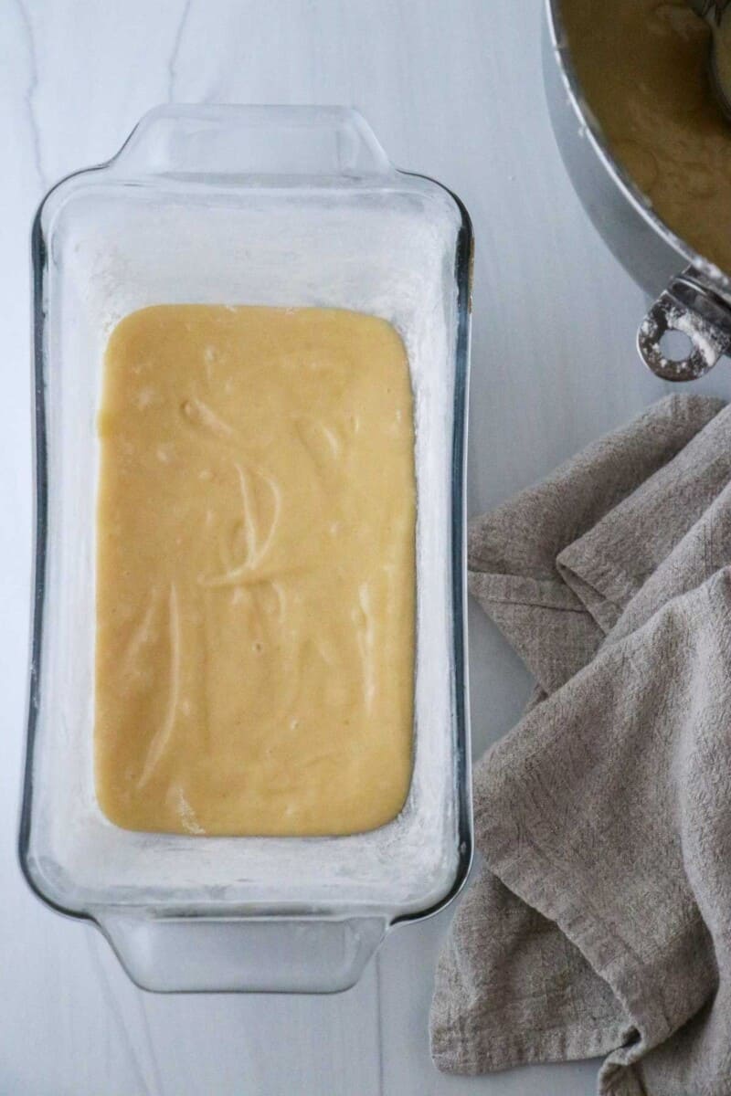 Vanilla cake batter in a glass loaf pan.
