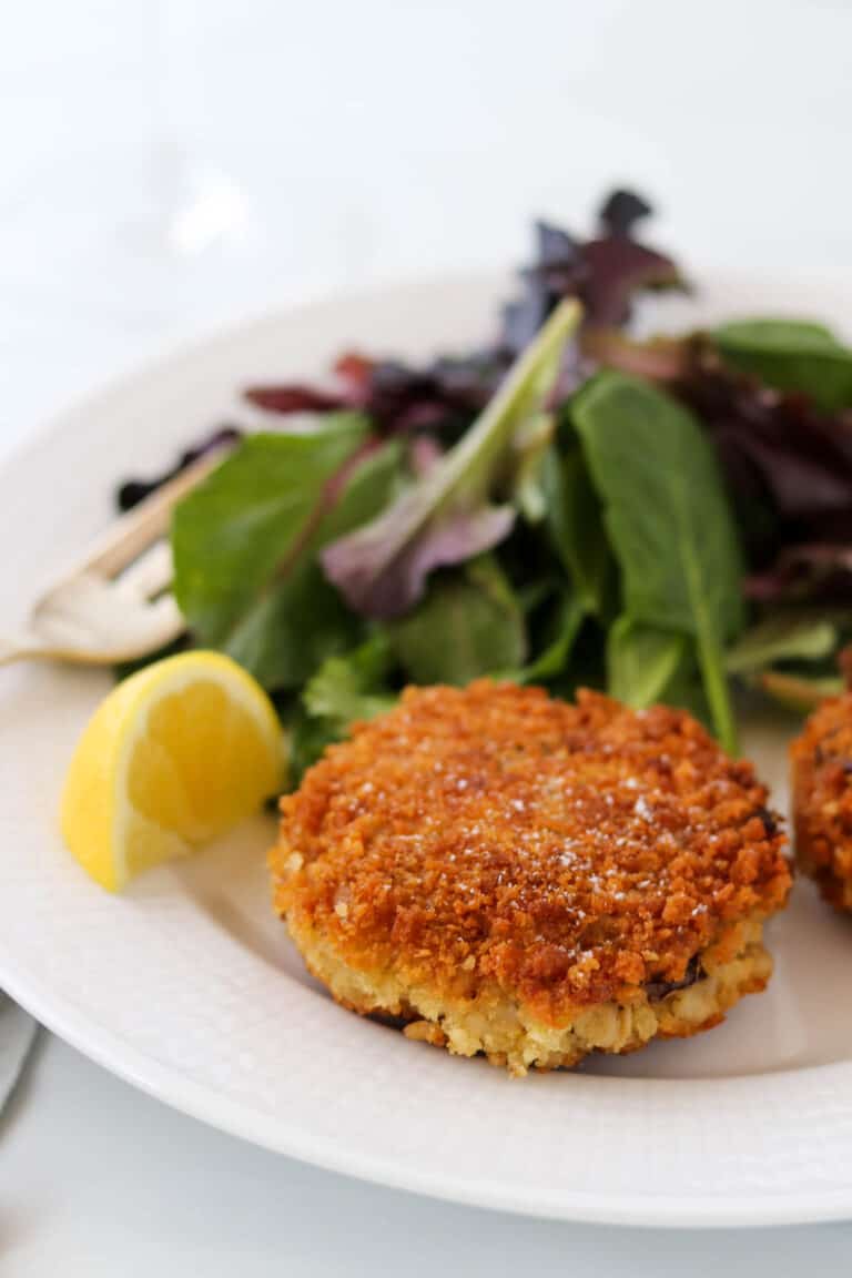 Cripsy Barley Risotto Cake next to a lemon wedge and salad.