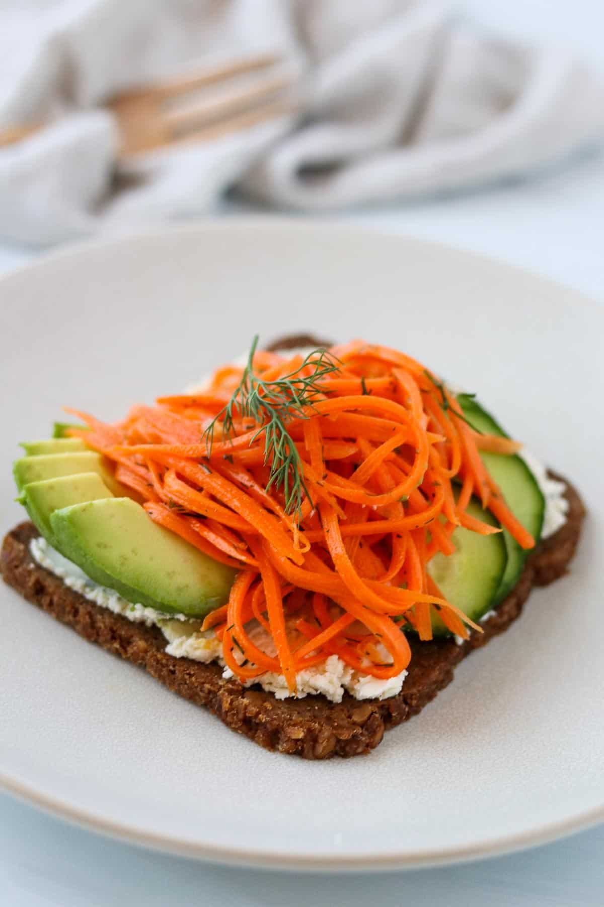 Side view of Carrot Salad Smørrebrød on a plate.