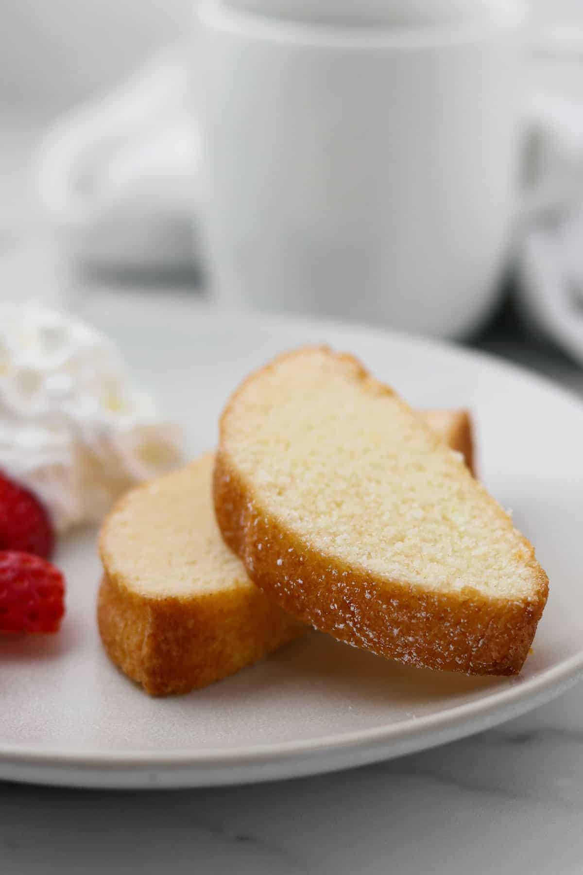 Slices of Swedish Almond Cake on a plate next to a mug.