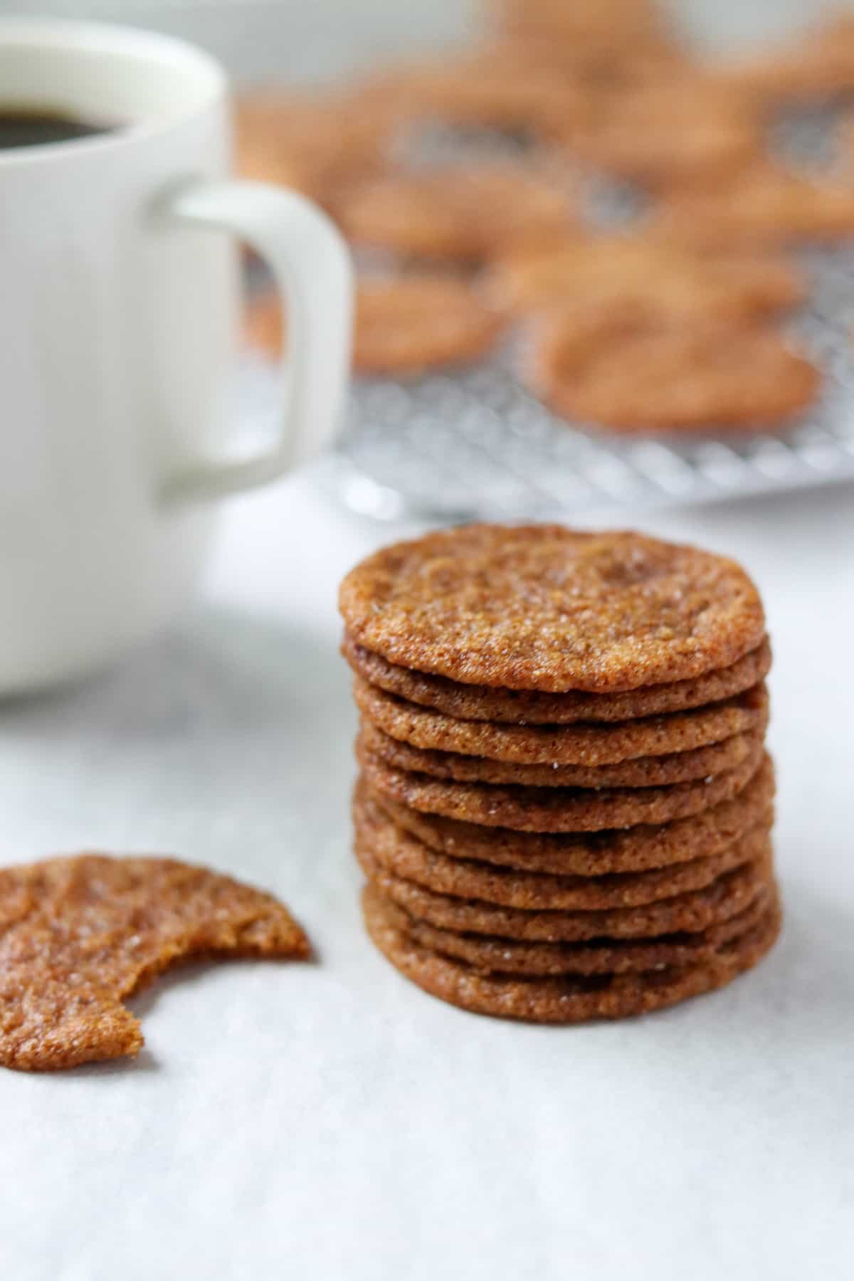 Stack of Swedish gingersnaps next to a cup of coffee.
