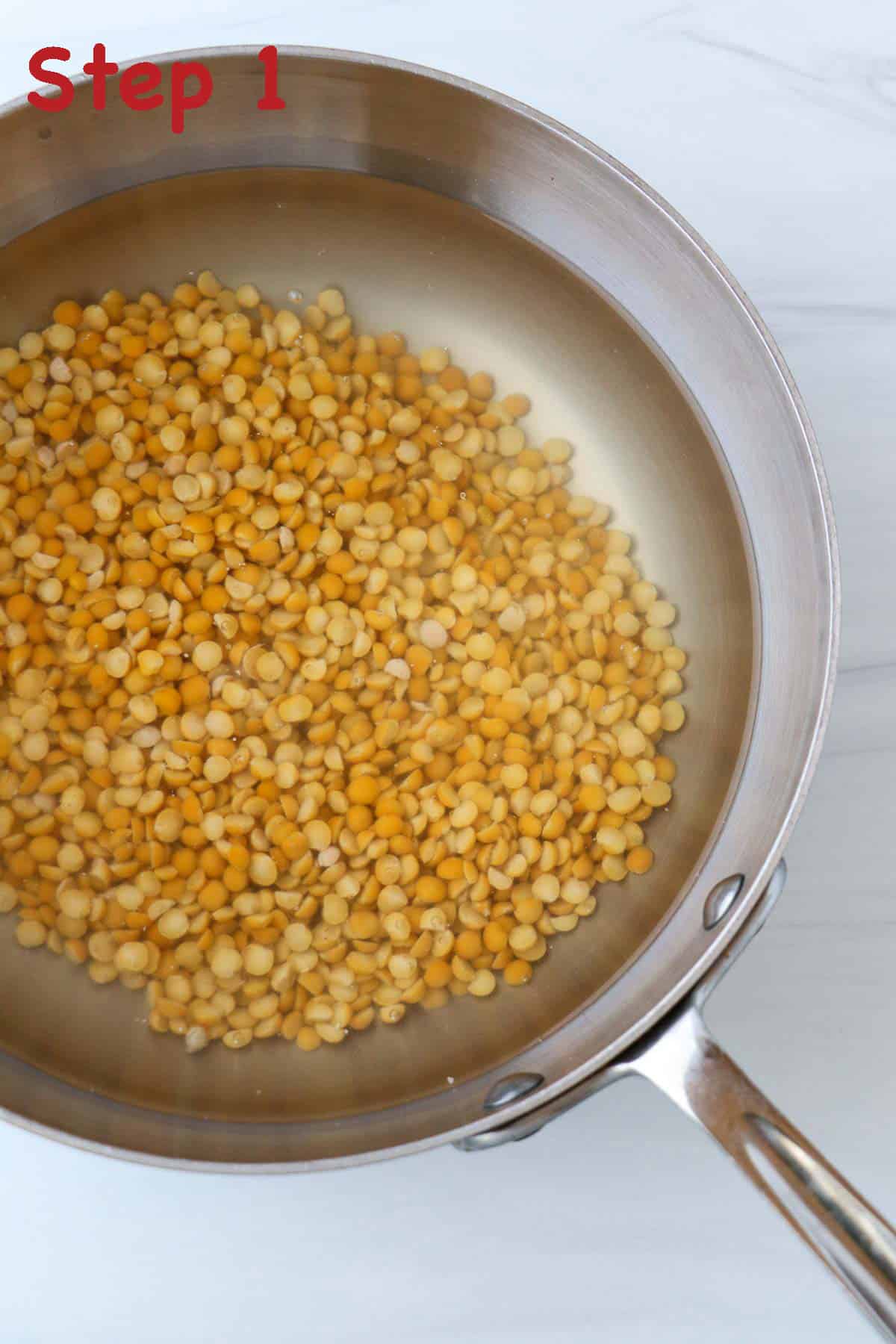 Uncooked yellow split peas and water in a saucepan.
