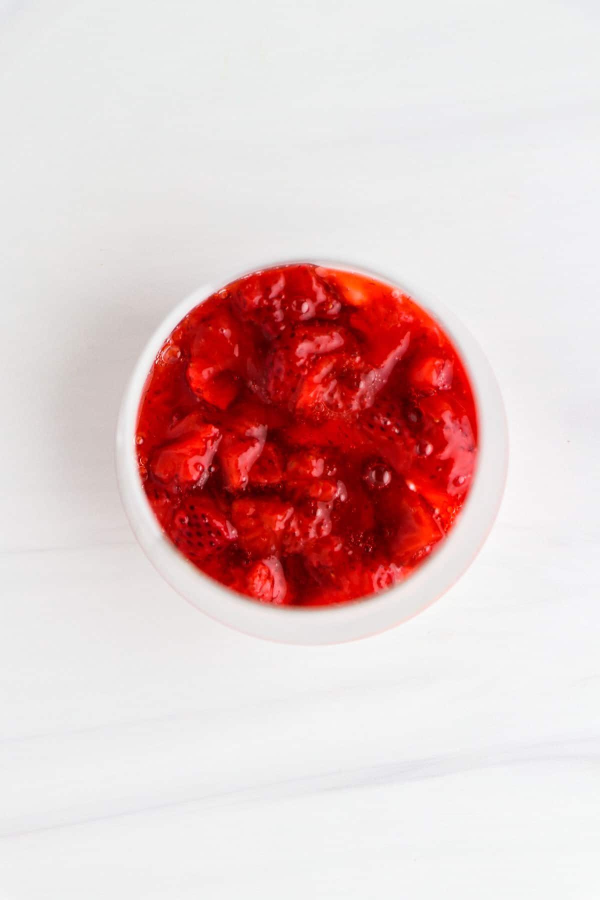 Overhead view of Roasted Strawberries in a glass.