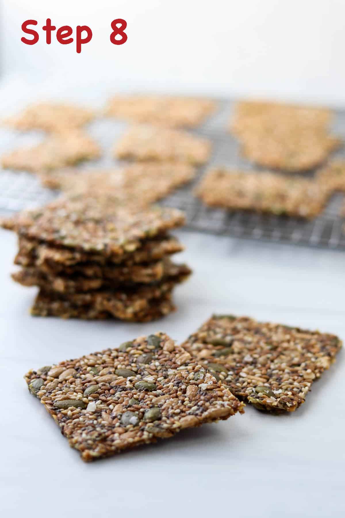Cut seed crackers on a white surface.