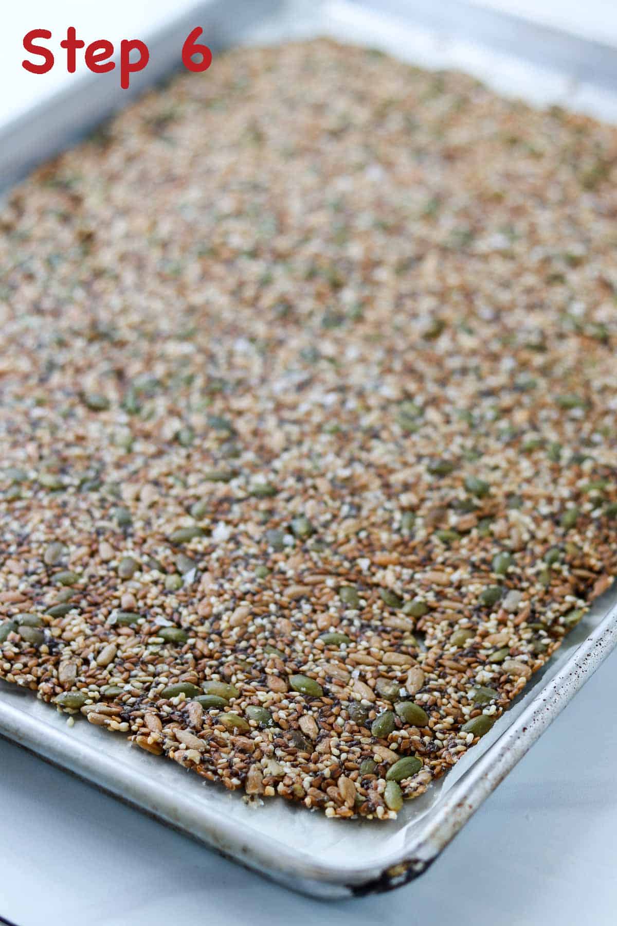 Baked seed cracker on a rimmed baking sheet.