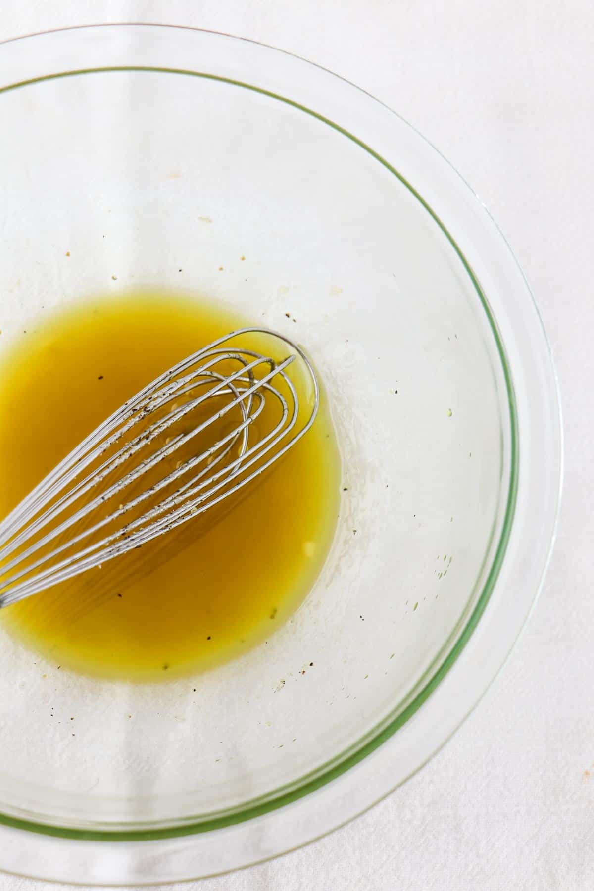 Vinaigrette in a bowl with a whisk.