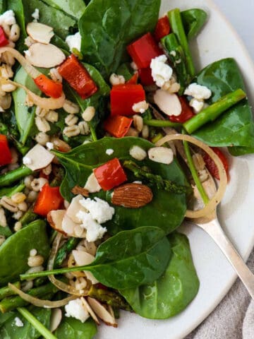 Spinach, asparagus and red pepper salad on a plate.