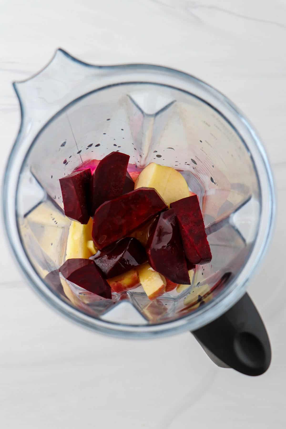 Chopped beets and apples in a blender.