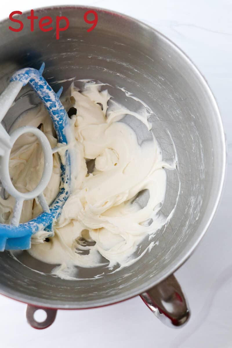 Cream cheese frosting in a mixer bowl with a paddle attachment.
