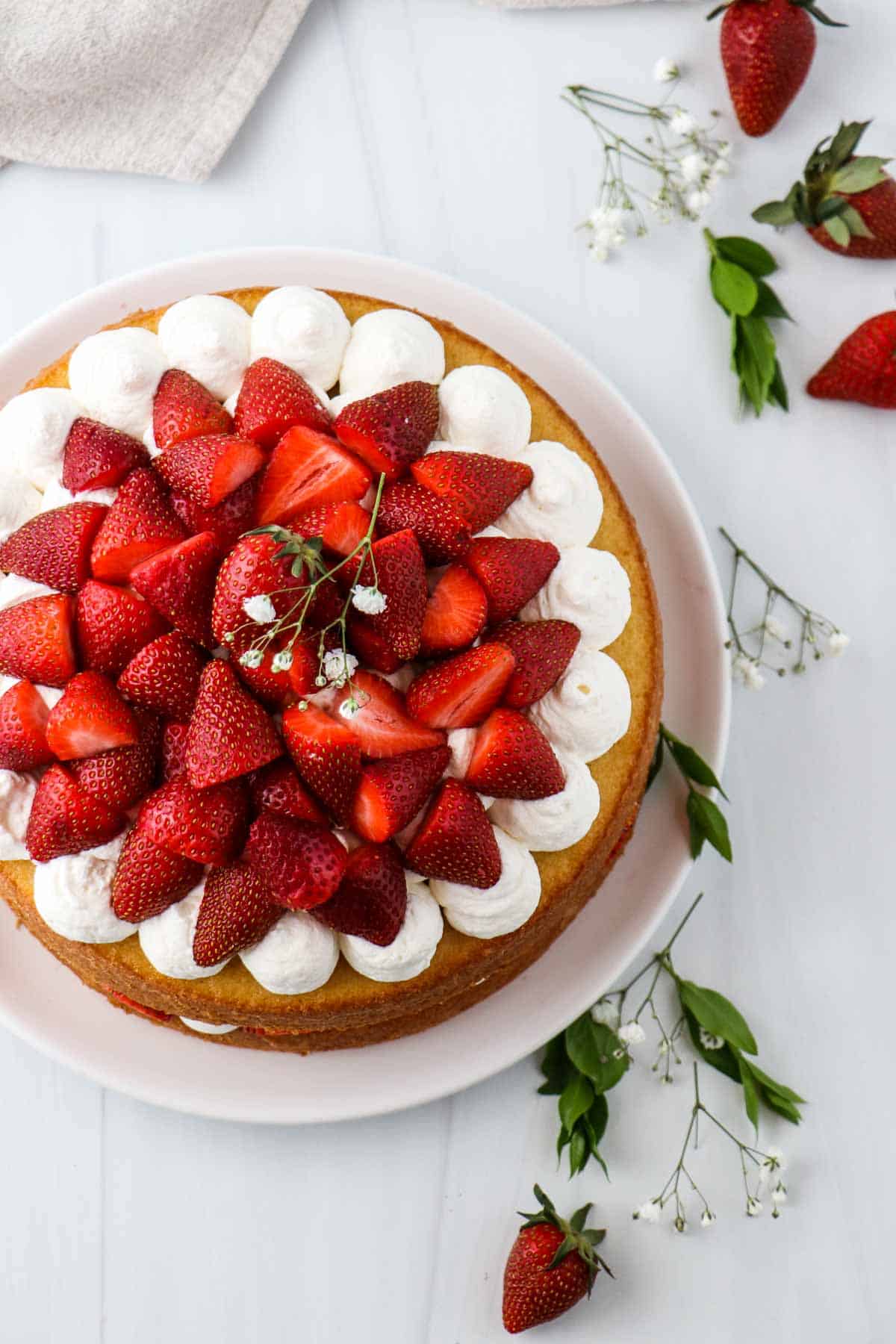 Overhead view of a cake topped with strawberries.