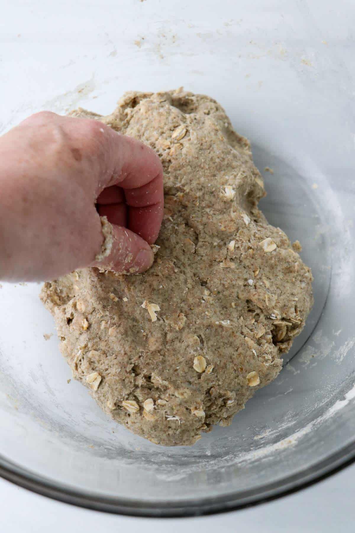 Someone kneading dough for Easy Swedish Crispbread (Knäckebröd) in a bowl.