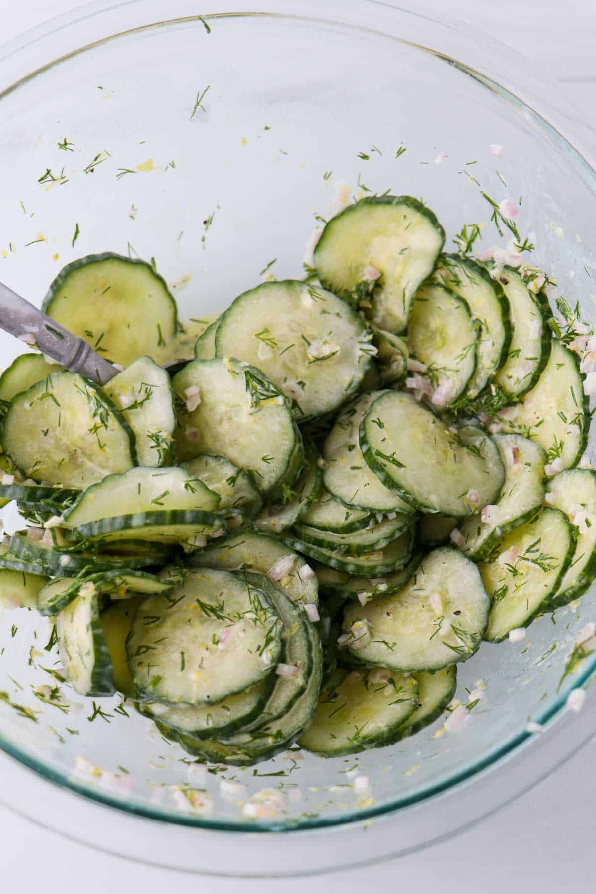 Lemon Cucumber Salad with Dill in a glass bowl with a spoon.