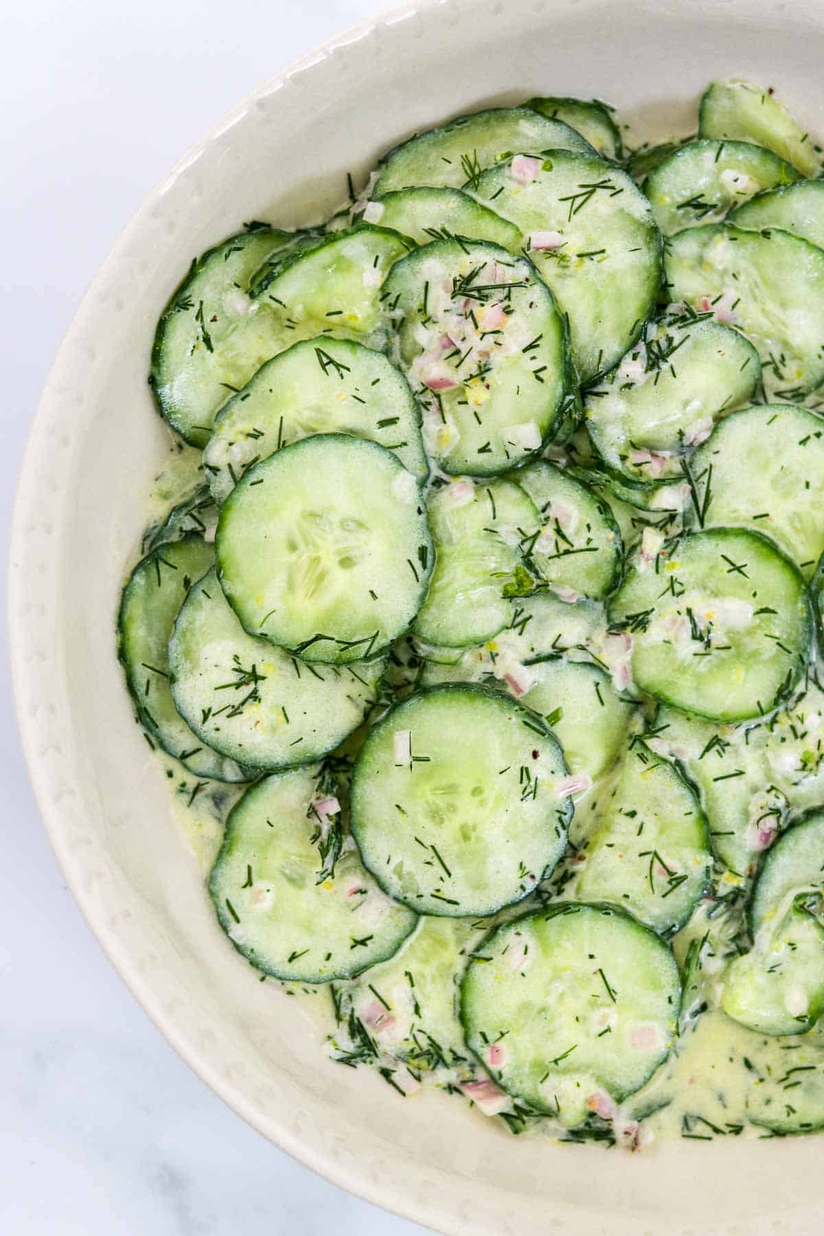 Lemon cucumber salad in a white bowl.