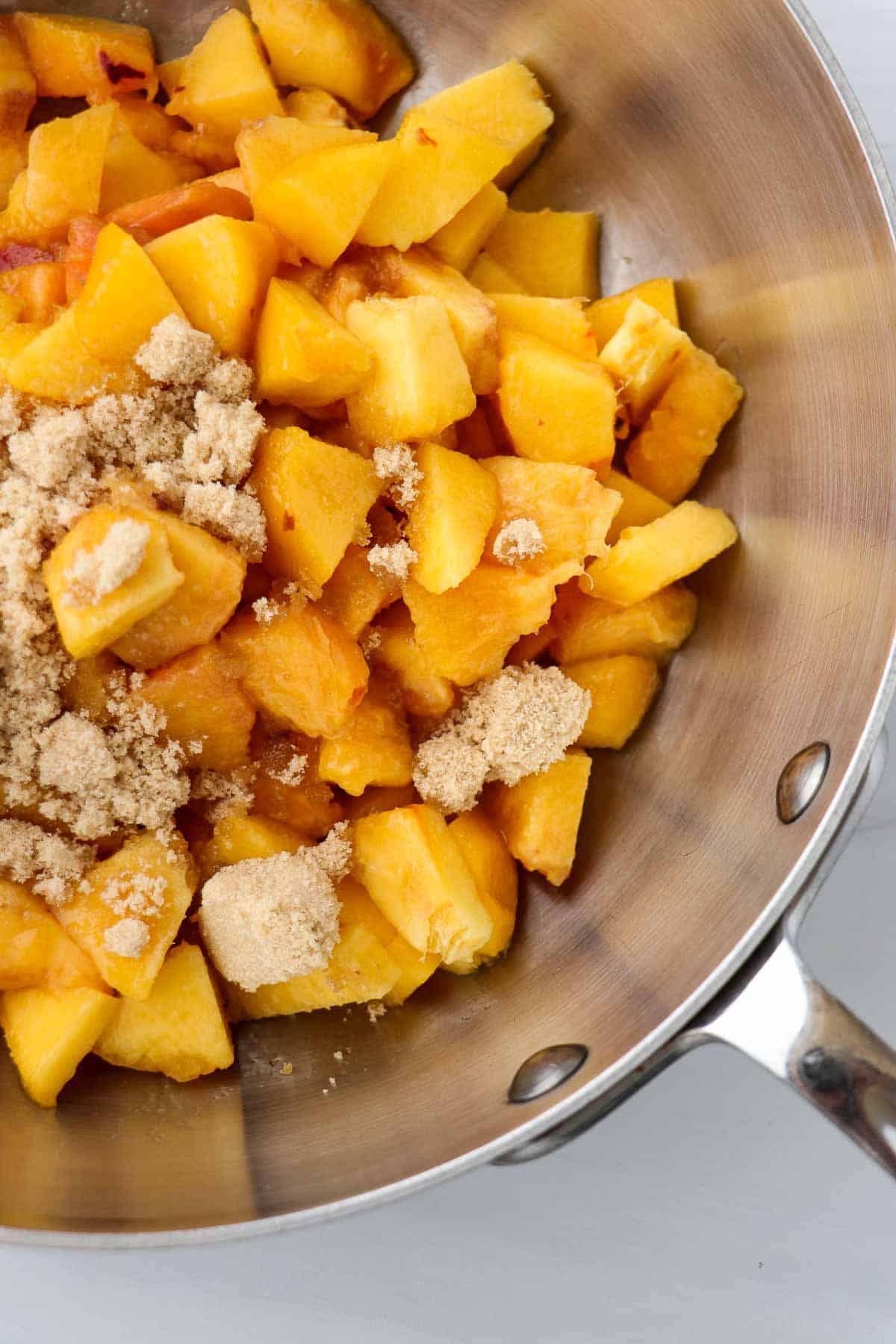 Peaches and brown sugar in a saucepan.
