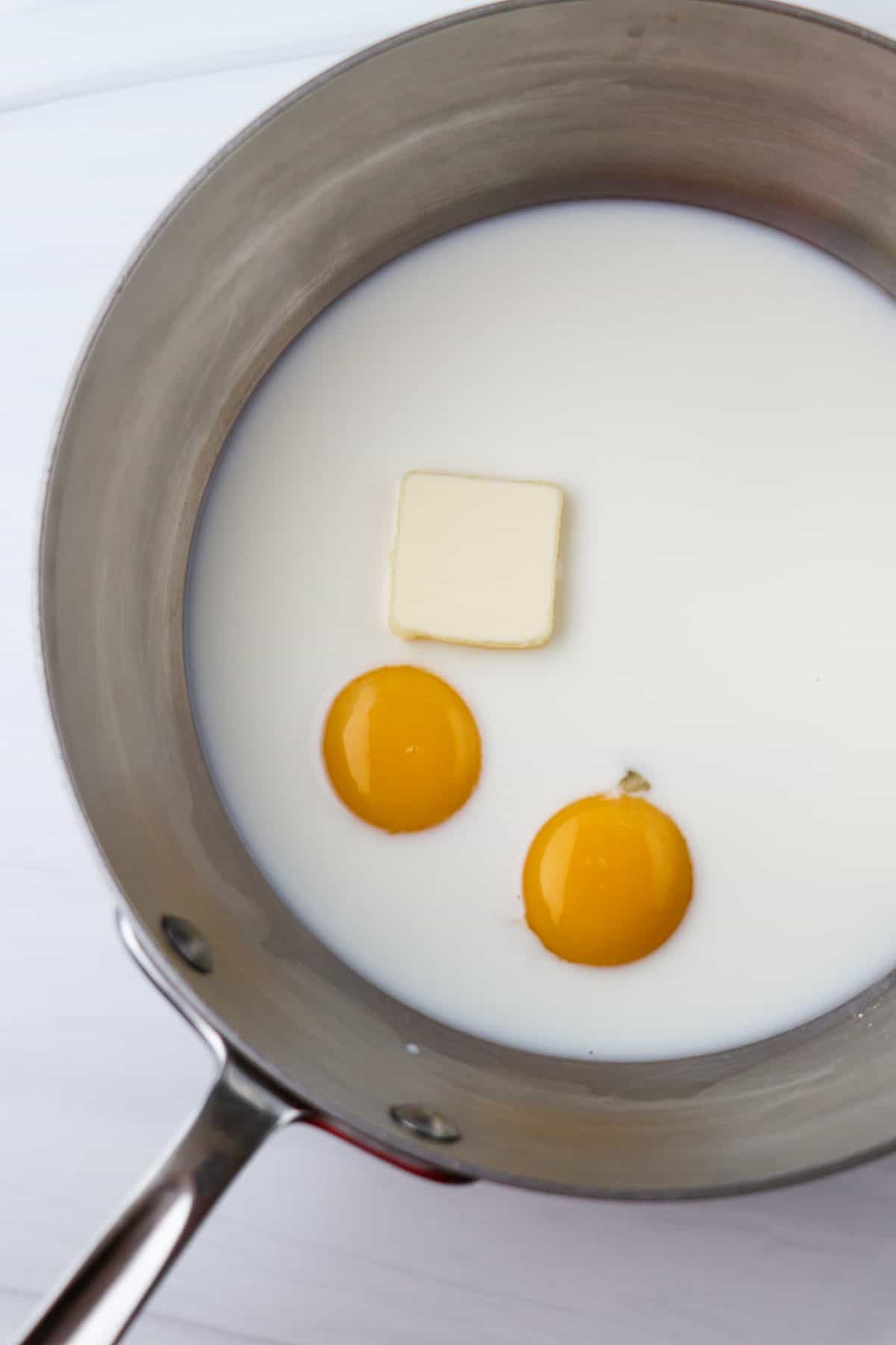 Eggs, milk and butter in a saucepan.