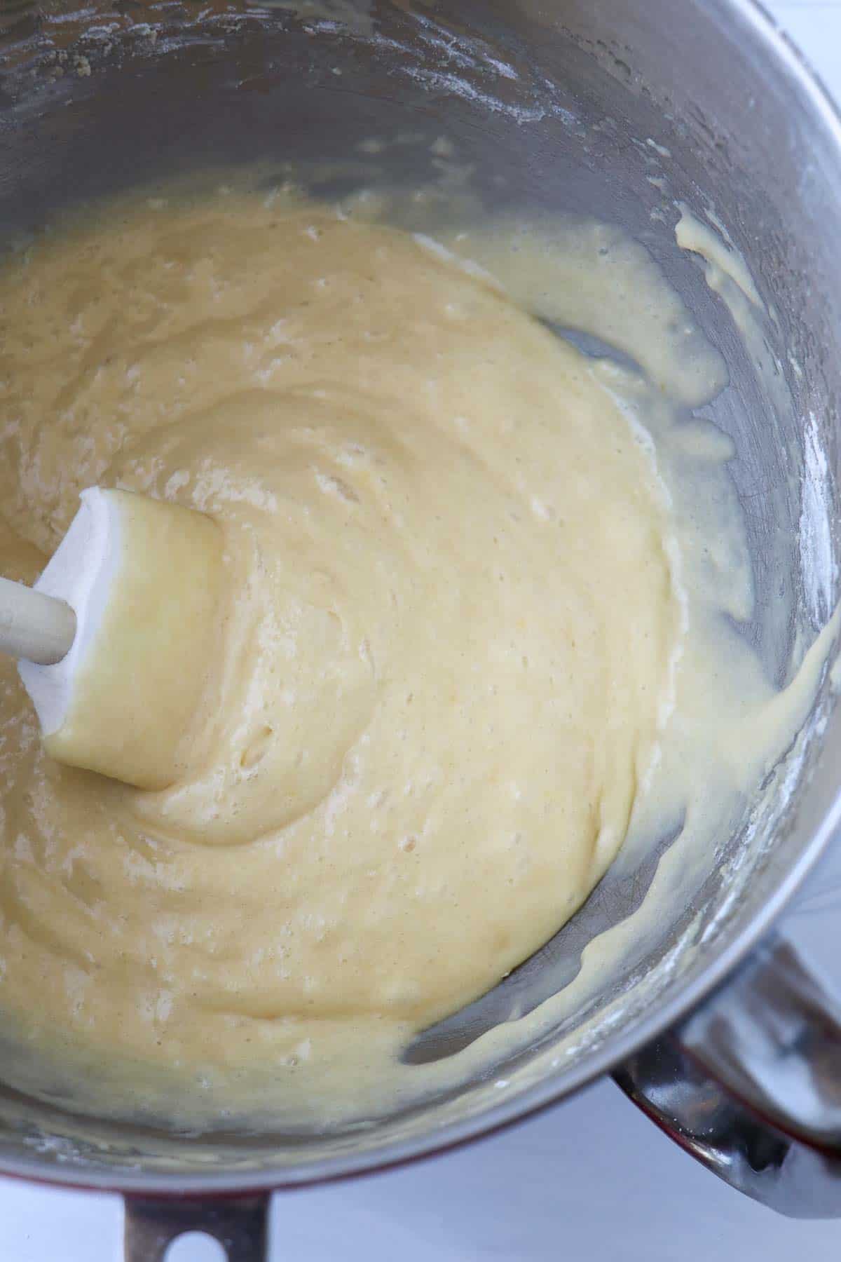 Vanilla cake batter in a bowl with a rubber spatula.