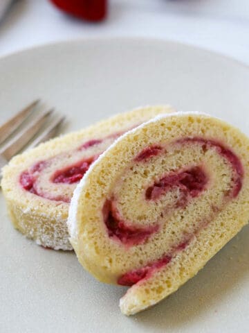 Close up of Strawberry Roll Cake slices next to a fork.