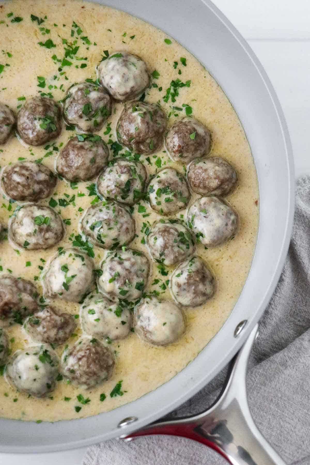 Swedish Meatballs with Gravy in a skillet sprinkled with parsley.