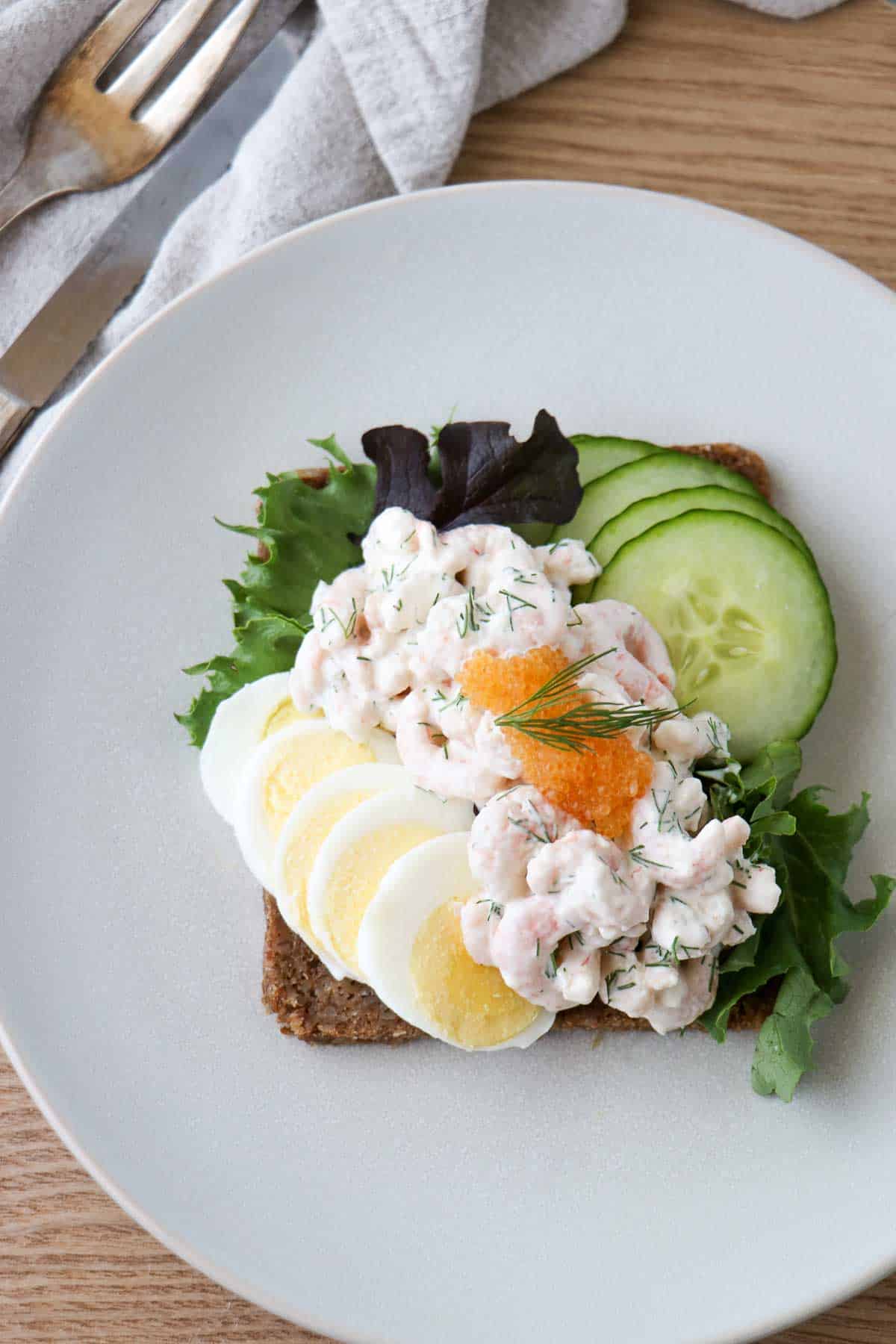 Skagenröra (Swedish Shrimp Salad) on rye bread with sliced hard boiled egg, cucumber and caviar.
