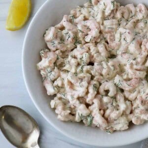 Close up of a bowl of Skagenröra (Swedish Shrimp Salad) next to a spoon and lemon wedge.