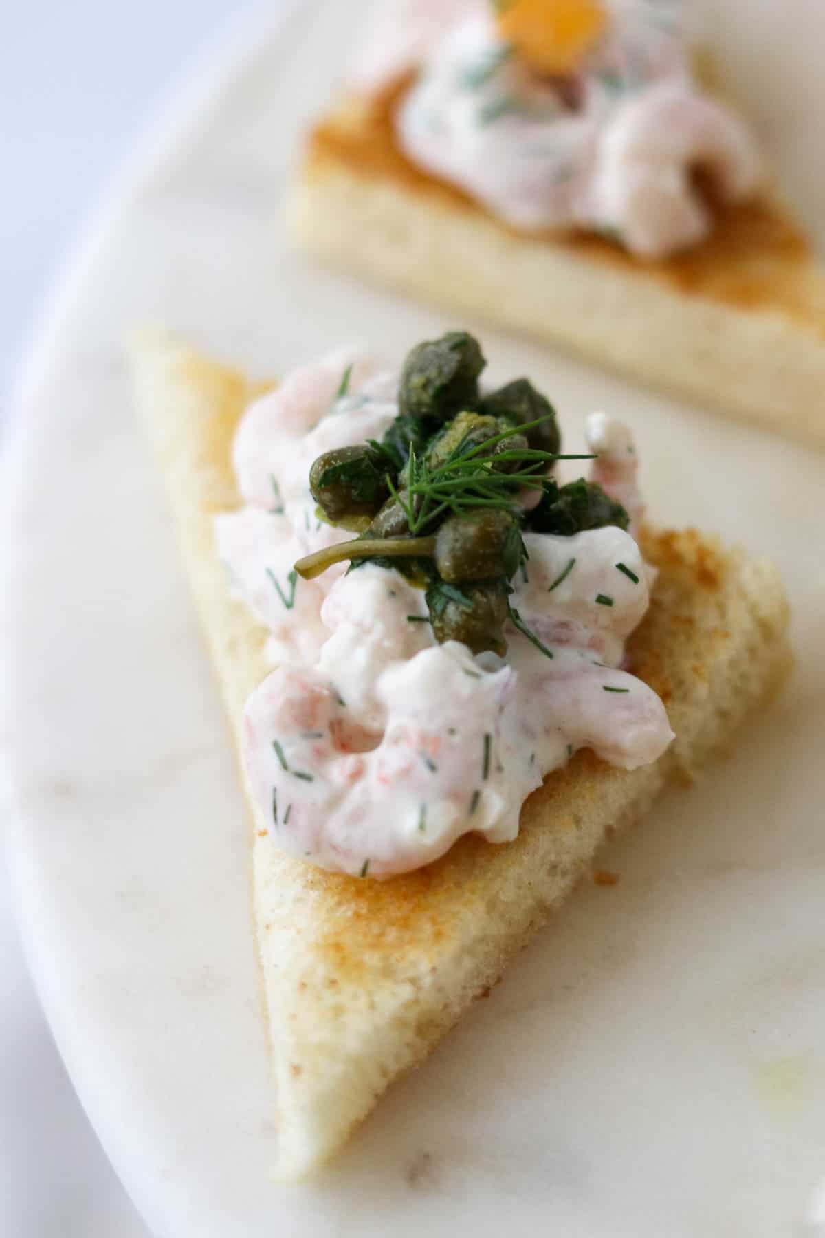 Close up of Toast Skagen topped with Caper Relish.