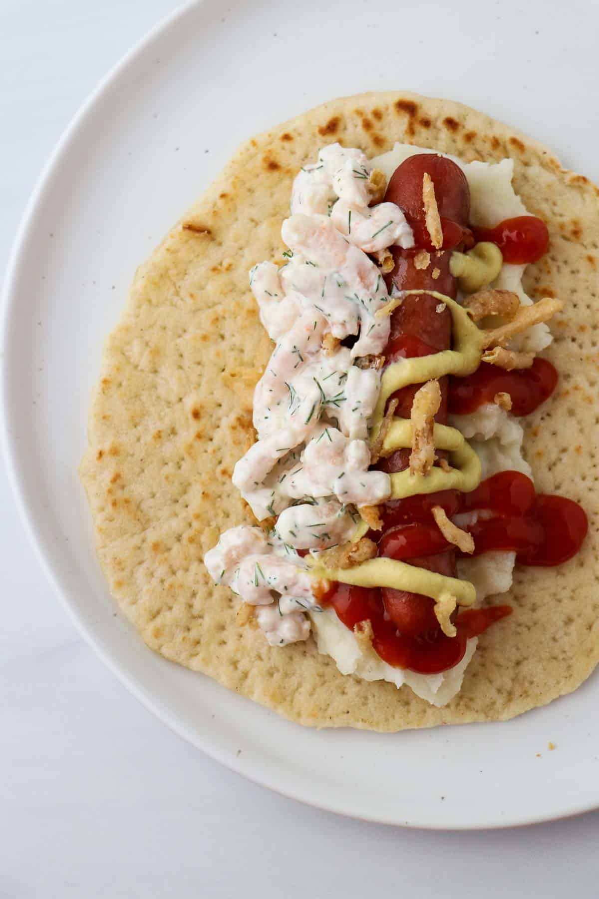 Hot dog and shrimp salad on a flatbread.