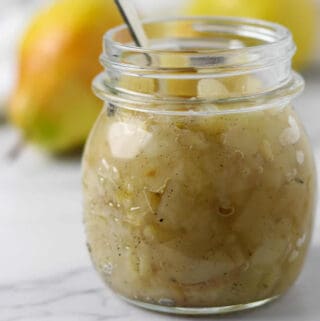 Spiced Pear Compote in a jar with a spoon.