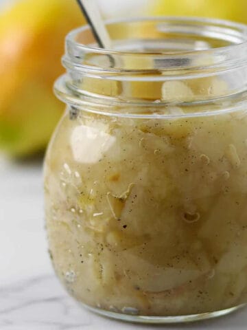 Spiced Pear Compote in a jar with a spoon.
