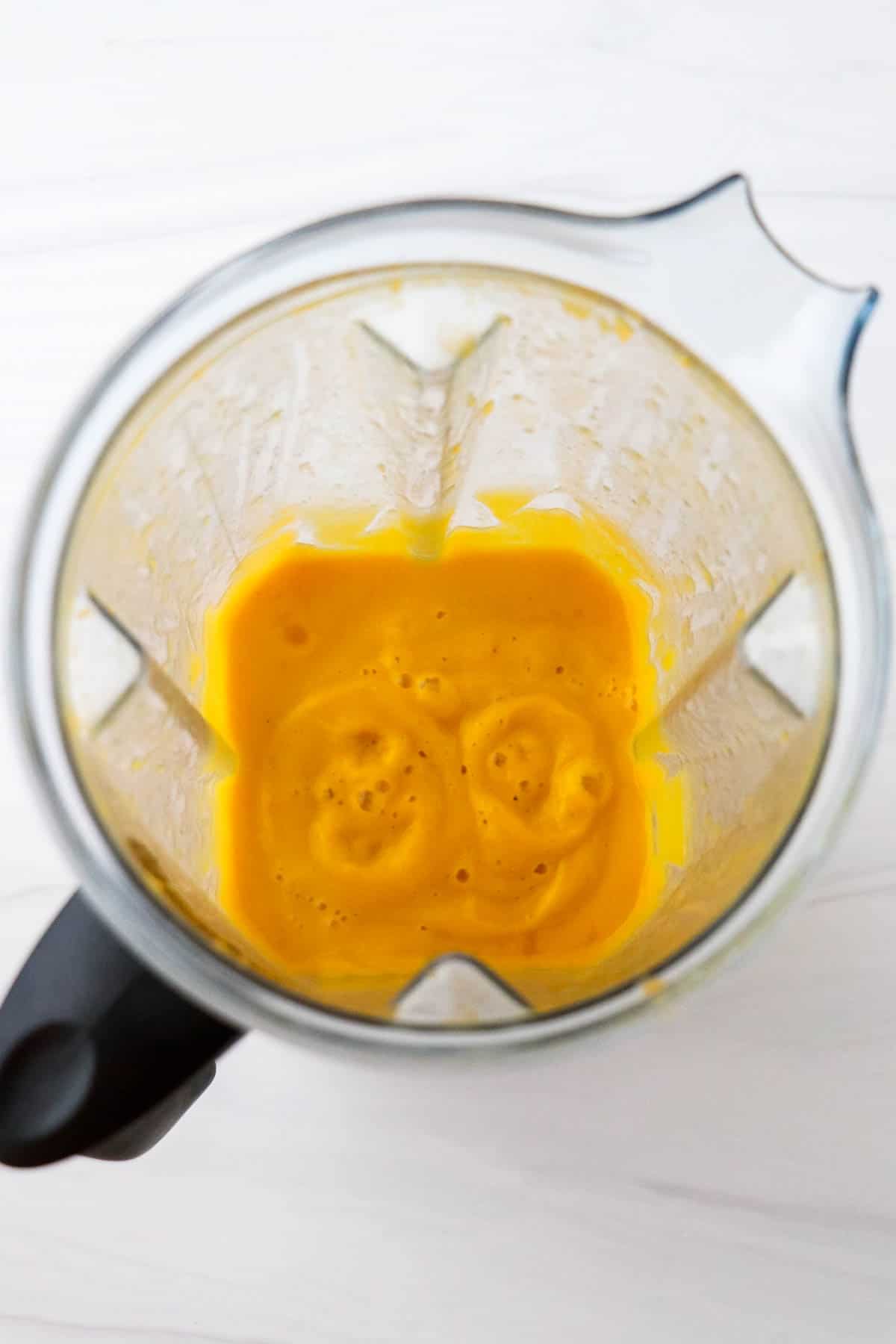 Puréed butternut squash soup in a blender.