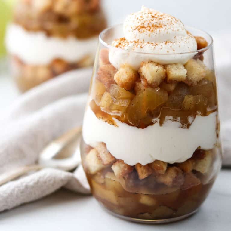 Close up of apple trifle topped with whipped cream.