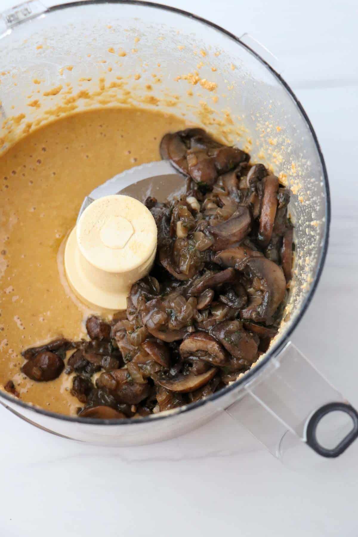 Almond paste and cooked mushrooms in a food processor.