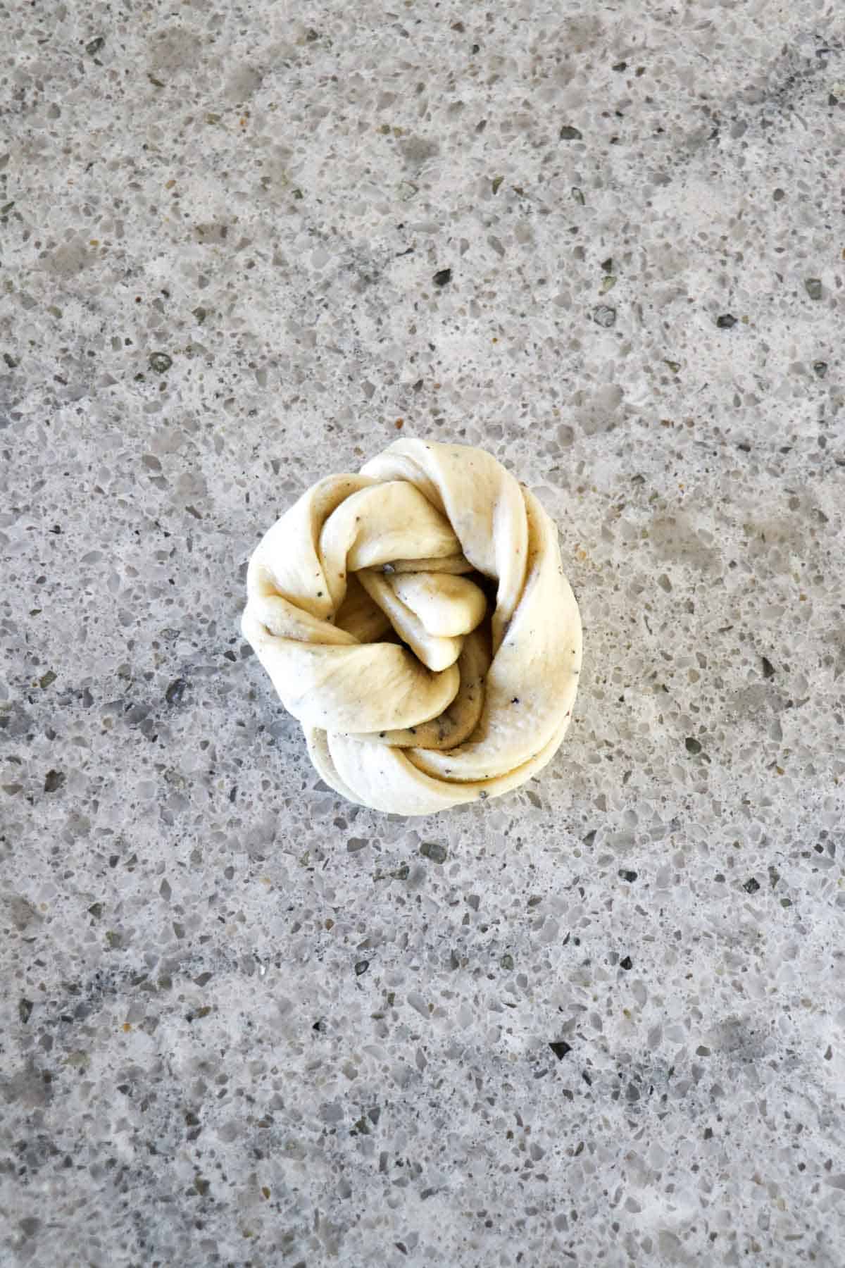 Unbaked cardamom bun on a kitchen counter.