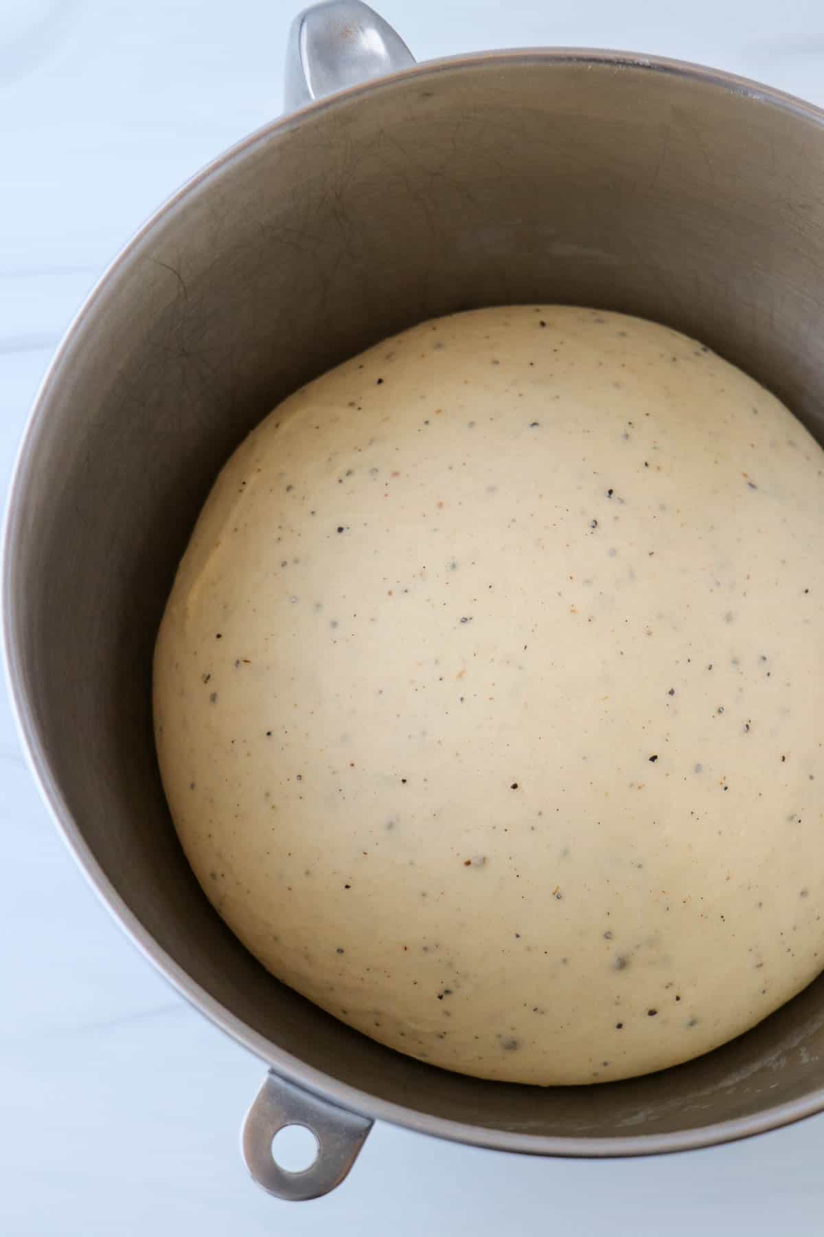 Risen cardamom dough in a metal bowl.
