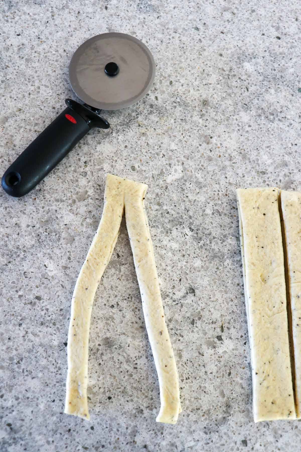 Strip of cardamom dough cut down the center.