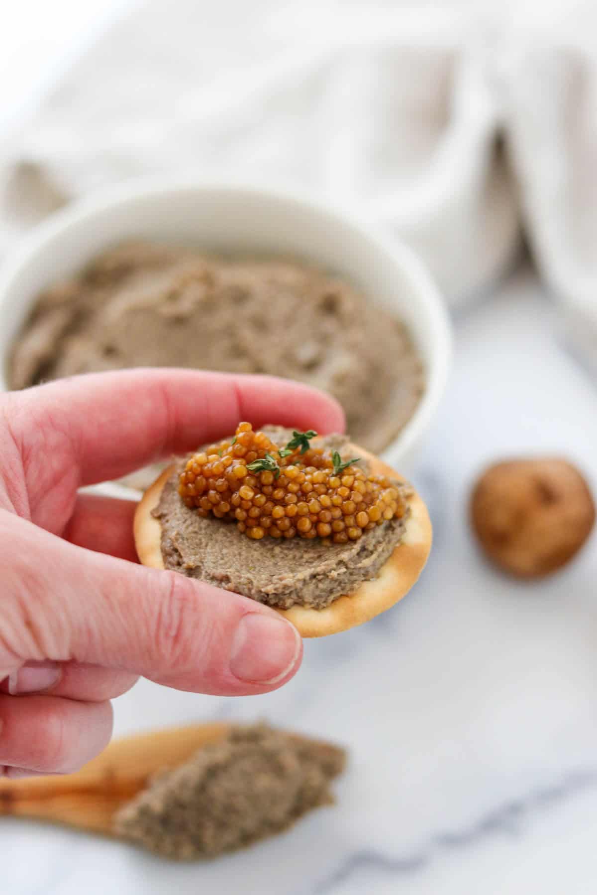 Vegetarian Mushroom Pâté on a cracker topped with pickled mustard seeds.
