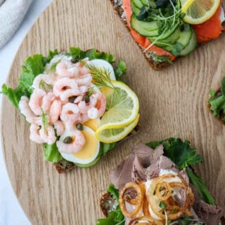 Shrimp smørrebrød on a wooden surface.