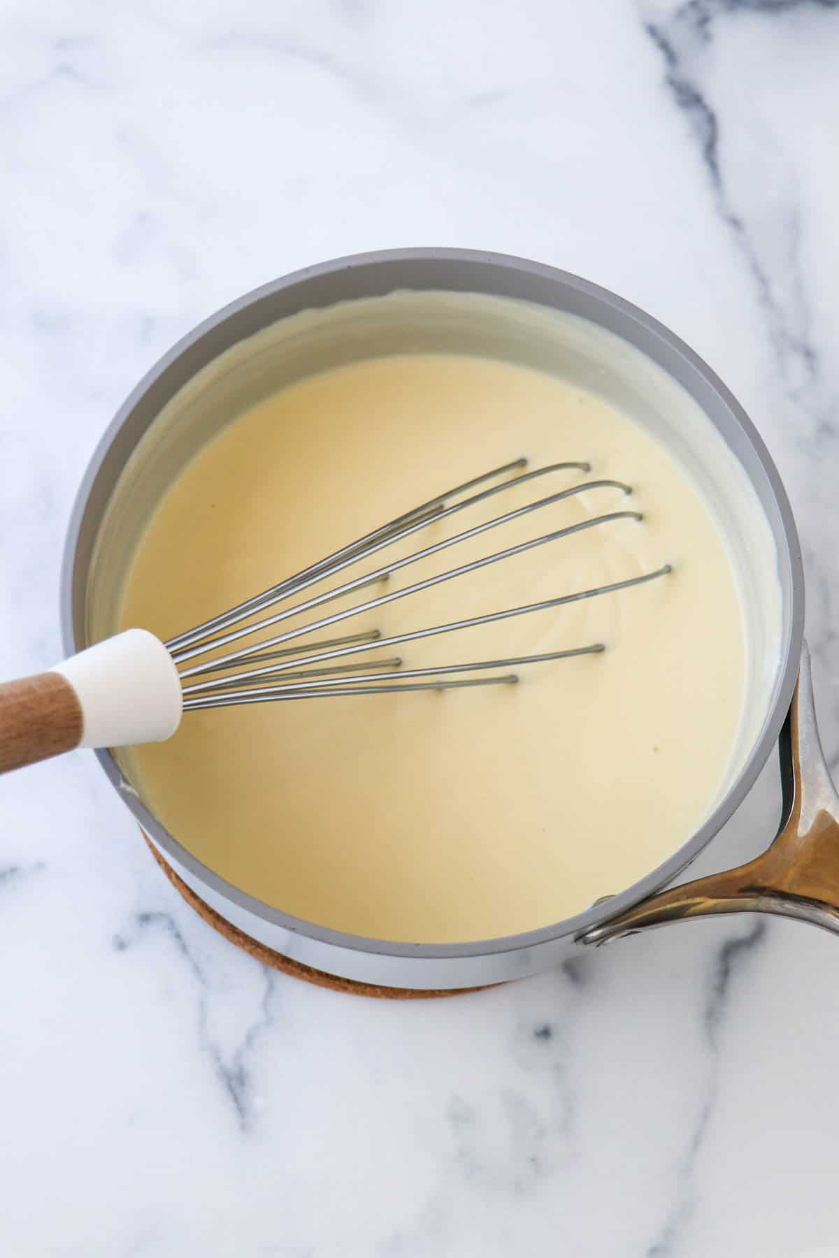 Swedish Cream in a Saucepan with a whisk.