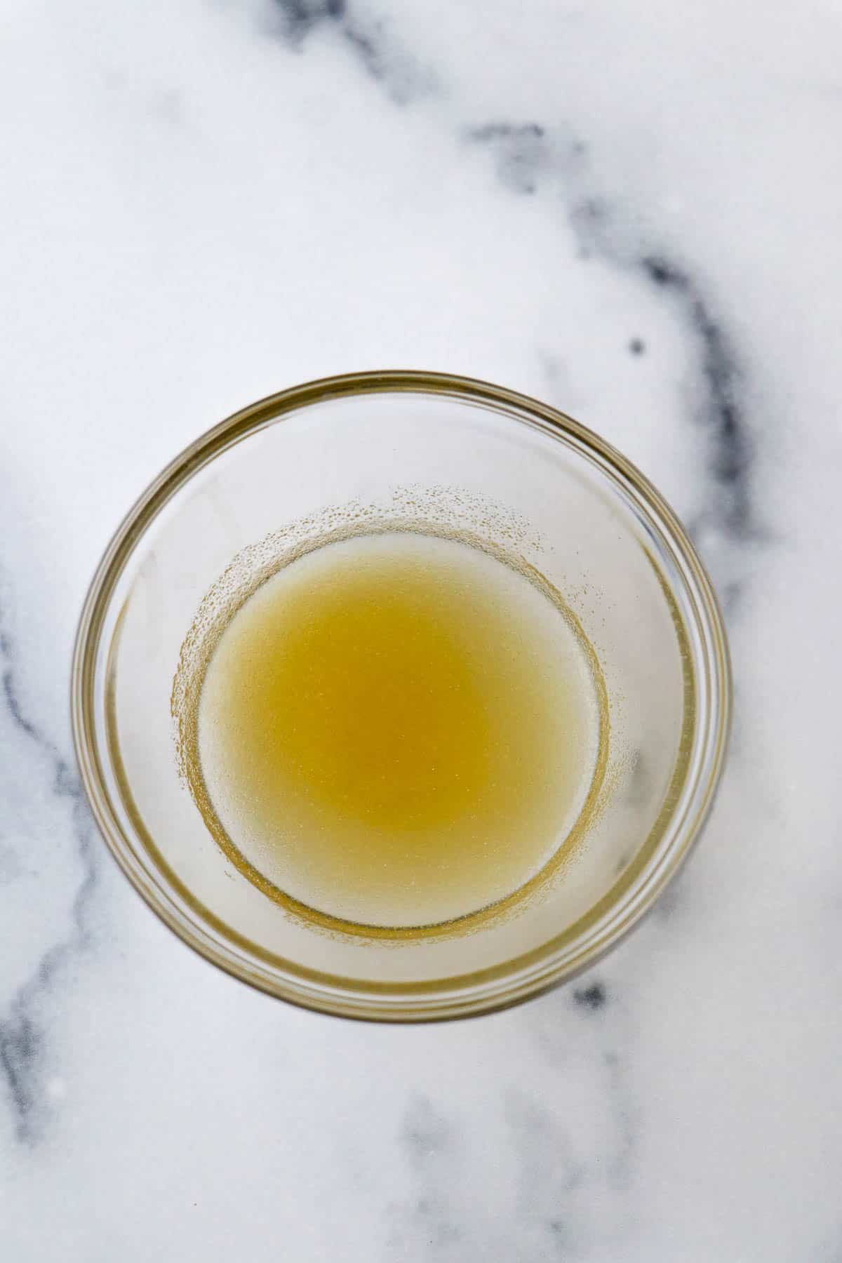 Gelatin and water in a small glass bowl.