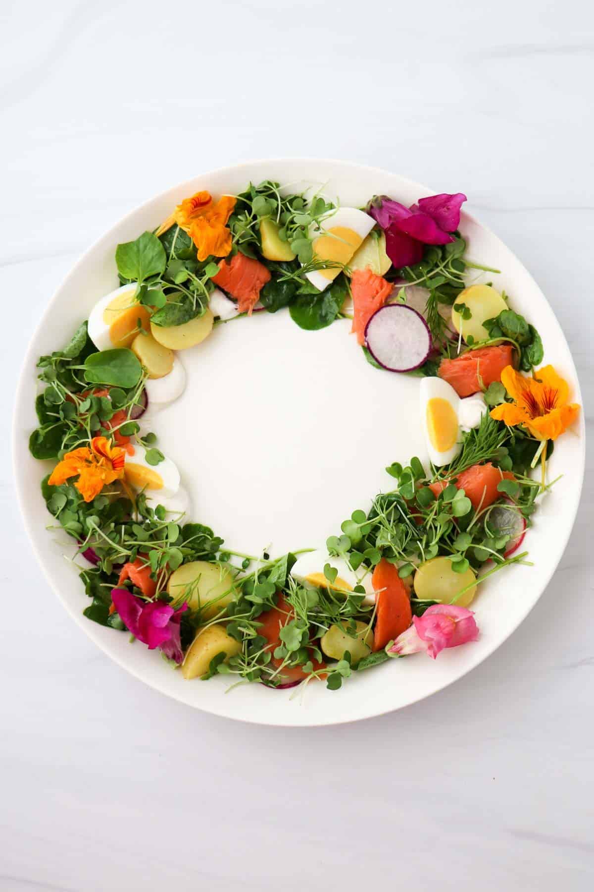 Midsummer Salad in the shape of a wreath on a white plate.