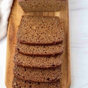 Kavring bread sliced on a wooden cutting board.