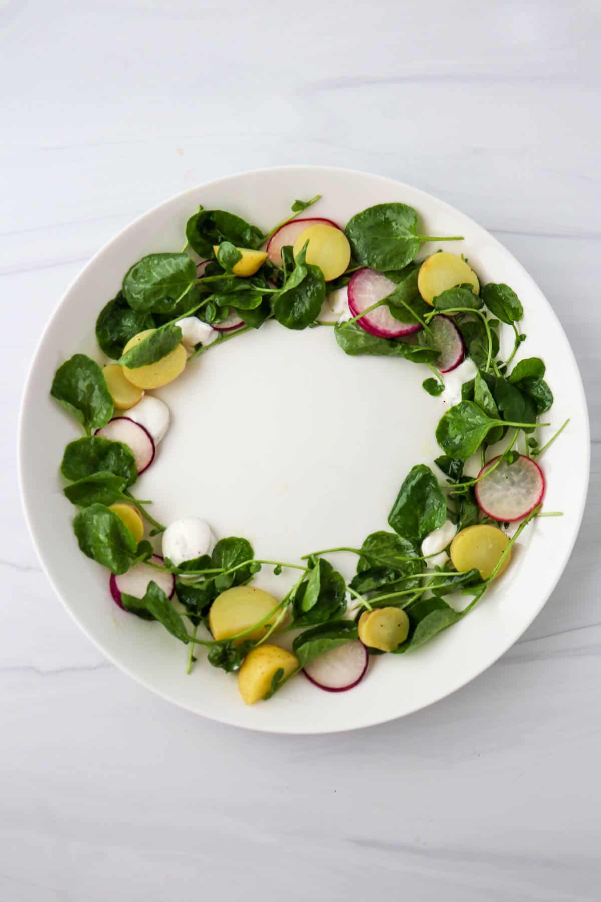 Partially assembled Midsummer Salad on a white plate.