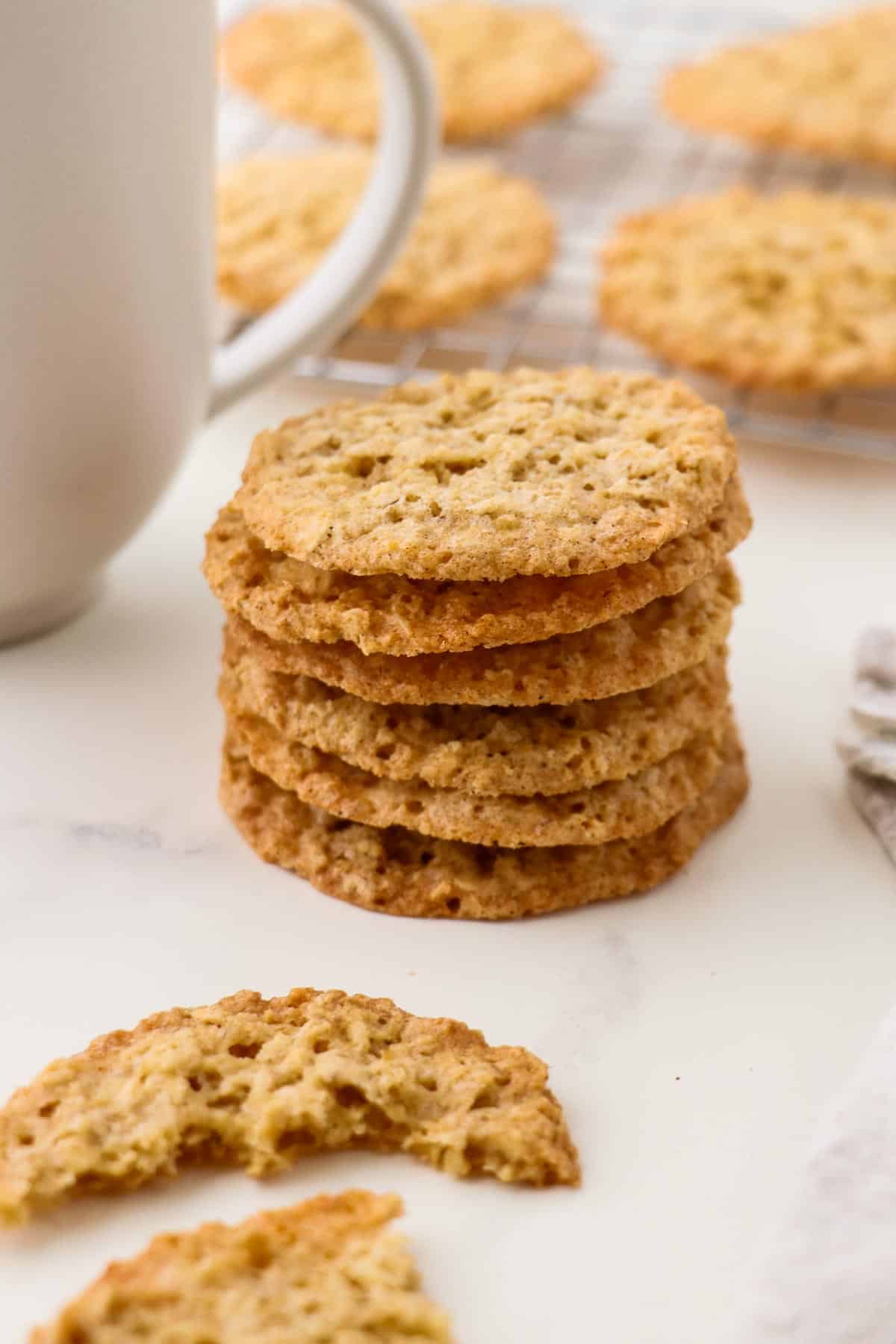 Stack of Swedish Oatmeal Cookies (Havreflarn) next to a cup of coffee.