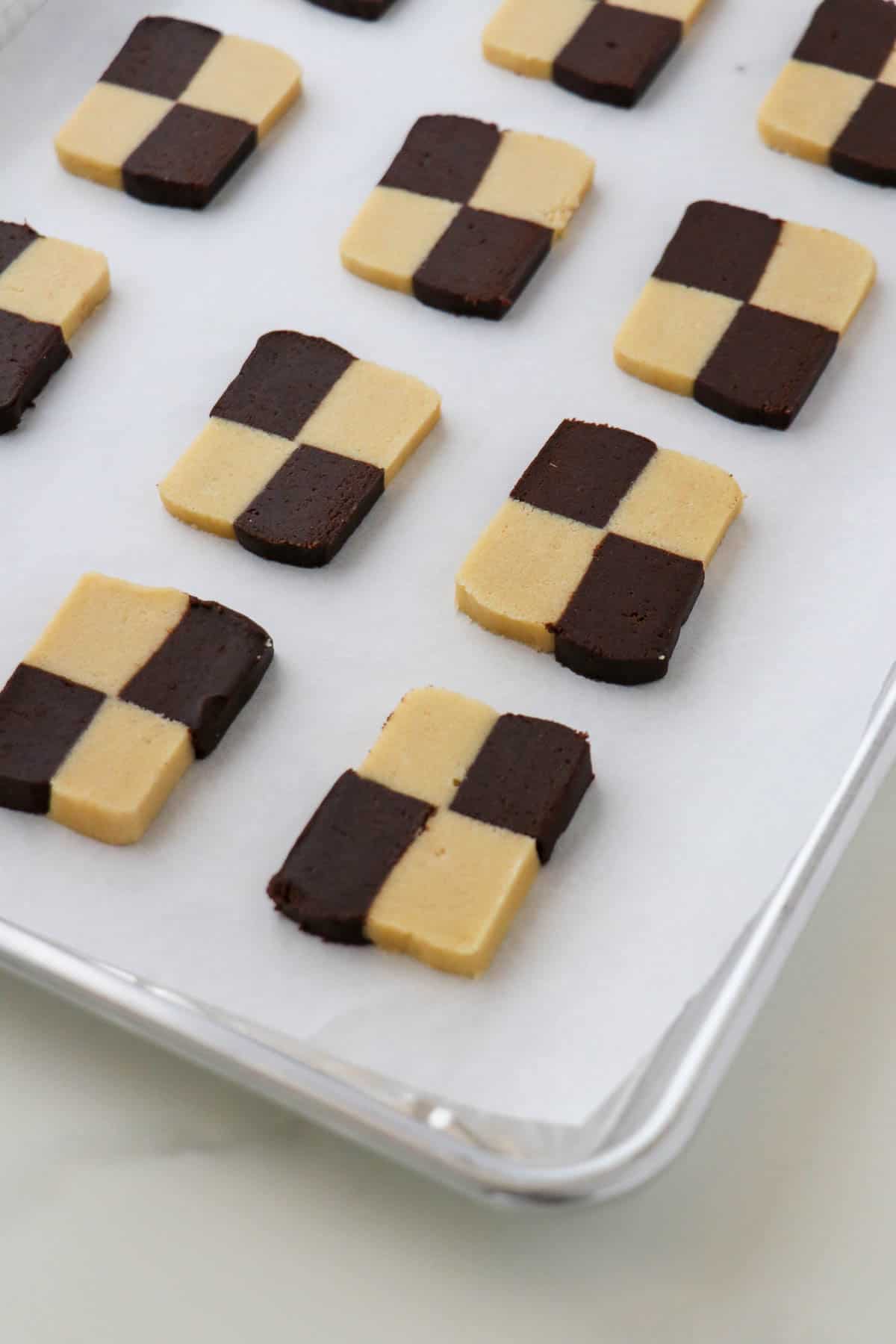 Unbaked checkerboard cookies on a baking sheet.