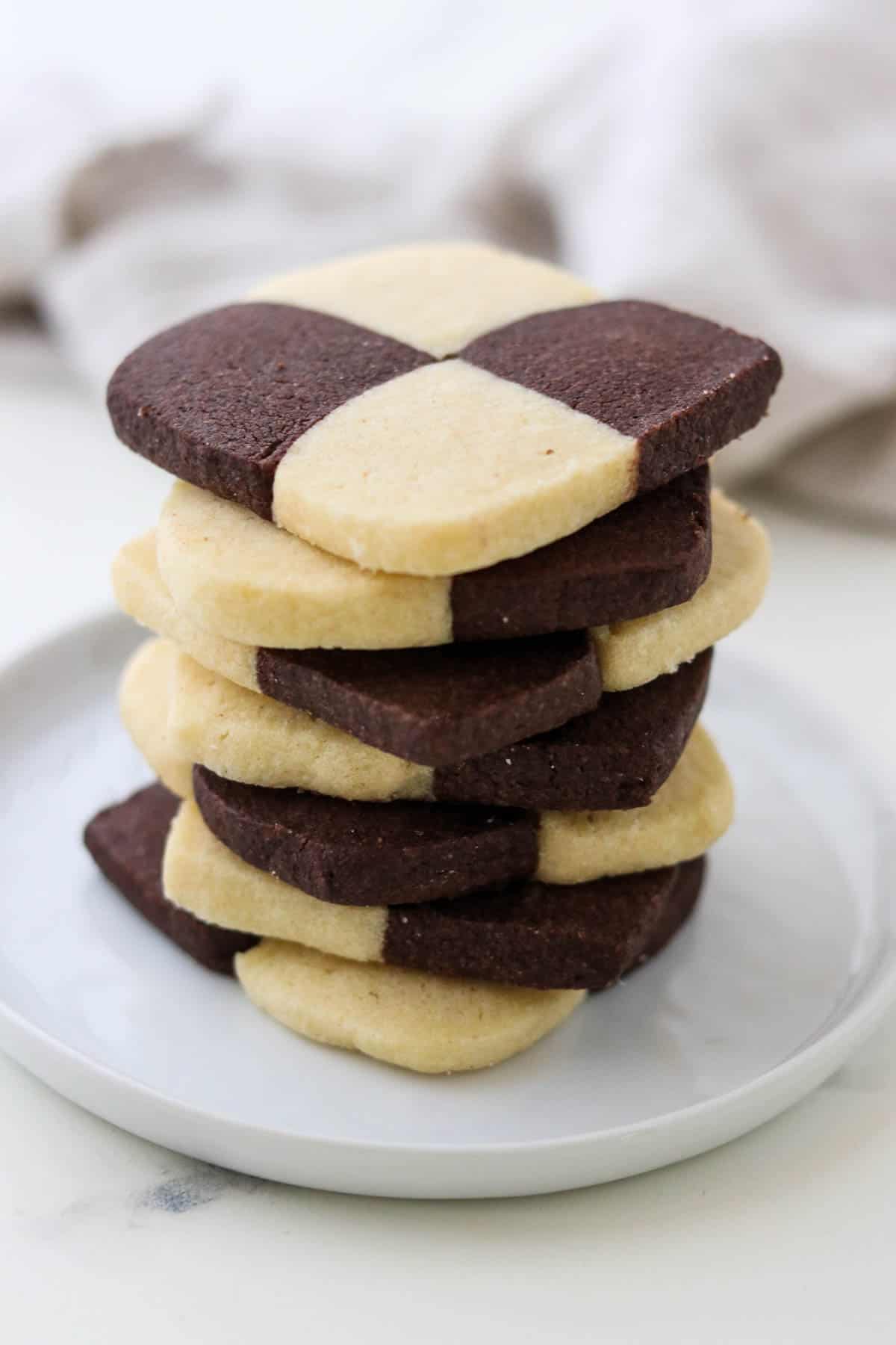 Stack of checkerboard cookies on a plate.