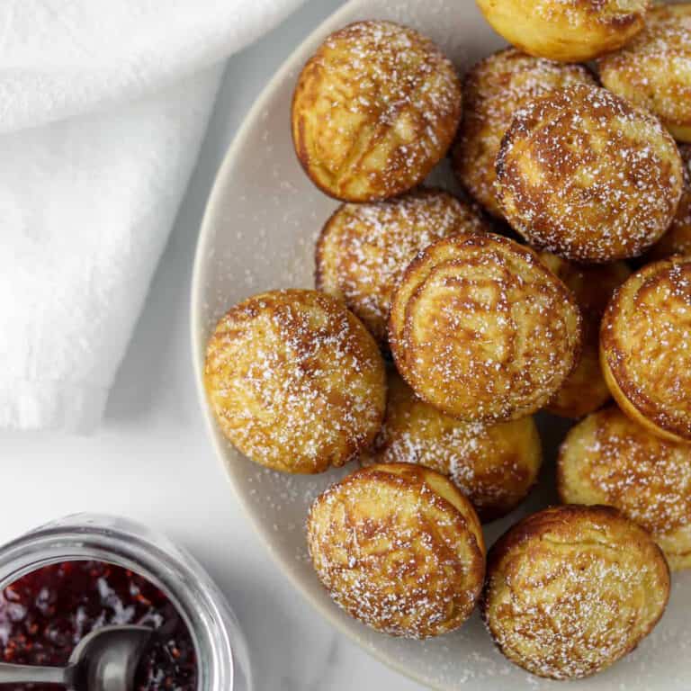 Close up of Danish Pancakes (æbleskiver) next to raspberry jam.